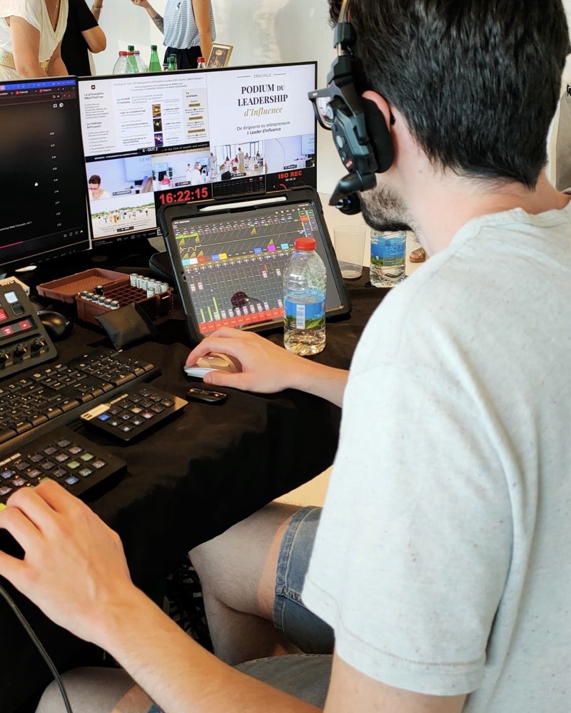 Maxime en régie, casque sur les oreilles, aux commandes de la console pendant un direct